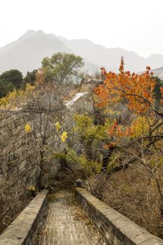 Exit leading out of Great Wall into woods with mountains and sky in background