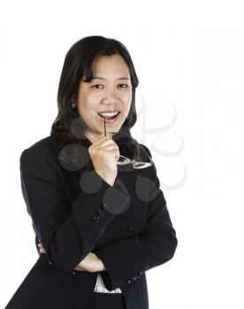 Mature Asian woman wearing business suit, holding glasses and thinking on white background