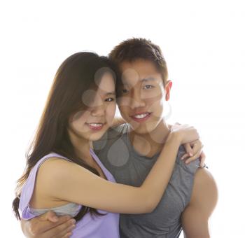 Photo, isolated on white, of a young adult couple holding each other while in dressed in workout clothes