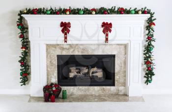 Natural Gas Fireplace decorated with Christmas ornaments, candles and basket of dried pine cones for the holiday season