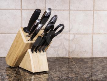Full kitchen knife set on stone countertop in kitchen