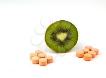 Half kiwifruit with Vitamin C tablets