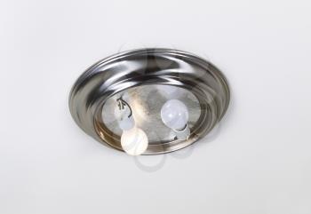 Photo of ceiling lights- incandescent type- with one bulb burnt out and one working with lid off