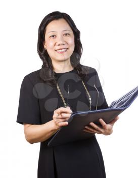 A portrait Vertical photo of a mature Asian woman wearing a dark dress while holding a folder, pen and glasses on a white background