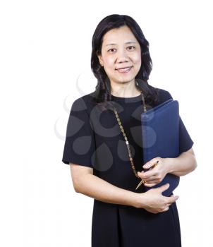 A portrait Vertical photo of a mature Asian woman wearing a dark dress while holding a closed folder and pen on a white background
