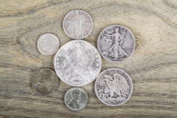 Old Silver Coins on faded white ash wood background