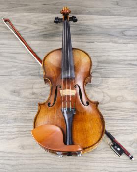 Antique violin and bow on faded wooden table background