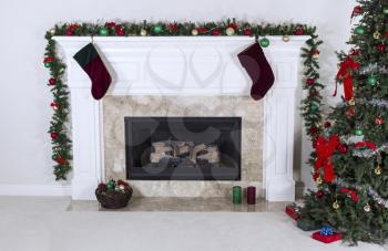 Natural Gas Fireplace decorated with tree, ornaments, stockings, basket and gifts