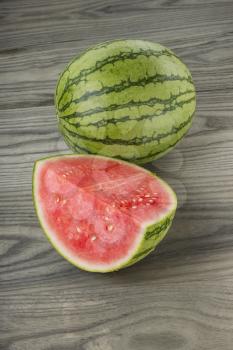 Whole and part water melon on natural aging white ash wood background