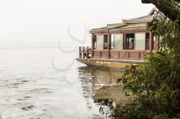Chinese Travel boat next to outlet on West Lake China in Hangzhou