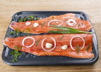 Wild Pacific Salmon Fillets in Bake Pan with fresh herbs on Bamboo Board