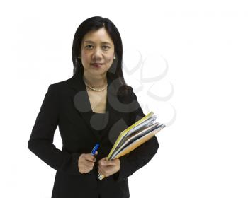 Asian woman dressed in business formal outfit holding notepads and pen on white background