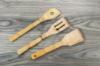 Three wooden spatulas on fading white ash wood background