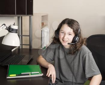Young girl getting ready to do homework with headset on while sitting at her desk