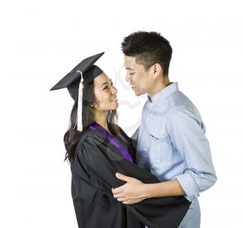 Photo of young adult woman, dress in graduation gown and cap, receiving congratulations from her boyfriend on a white background