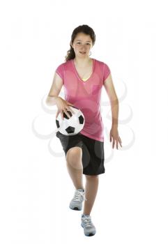 Vertical photo of young girl, soccer ball on thigh, on white background
