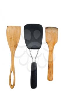 Vertical photo of three kitchen spatulas, two of them wooden, isolated on white 