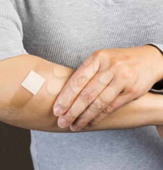 Photo of female forearm with bandage covering cut 