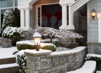 Closeup photo of home entrance during the holidays with fresh snow 