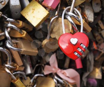 Photo of red heart shaped lock with many other locks in background