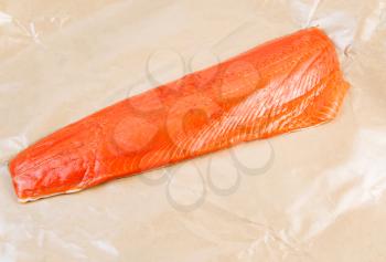 Horizontal photo of fresh Wild Red Salmon Fillet wrapped in wax paper 