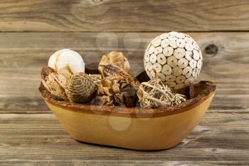 Closeup horizontal photo of home decorations place inside of a wood basket on rustic wooden boards 