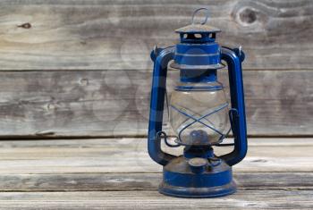 Front view of an old dirty lantern on rustic wood