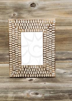 Vertical photo of wooden picture frame, empty inside, on rustic wood