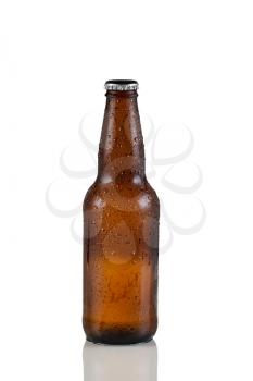 Closeup vertical image of a single unopened cold brown beer bottle covered with dew on white with reflection