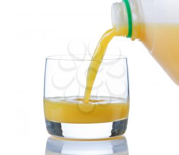Pouring fresh orange juice, from gallon container, into glass on white with reflection