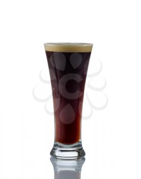 Vertical image of a tall glass filled with dark stout beer on white with reflection