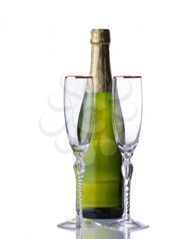 Empty tall elegant drinking glasses with unopened bottle of sparkling wine isolated over white background with reflection 