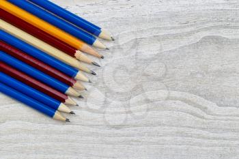 Pencil tips lined up on rustic white wood 