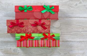Top view of holiday gift wrapped boxes on rustic white wood 
