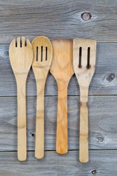 Vertical image of old wooden cooking utensils on rustic wood 