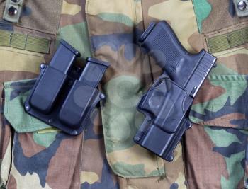 Top view angled shot of United States military uniform with weapon in horizontal layout.  