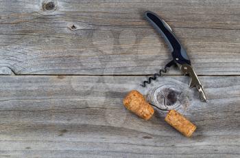Top view angled shot of wine bottle opener with corks on rustic wooden boards