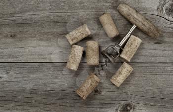 Several used corks and opener on aged cedar wooden boards in vintage style. Top view angled shot in horizontal format with copy space. 