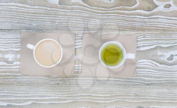 Top view shot of coffee and green tea drinks on aged white wood surface in horizontal format.