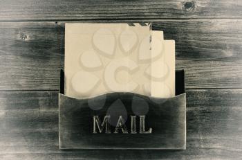 Vintage concept of an old metal mailbox with letters inside on rustic wood
