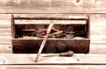 Vintage concept of an old tool box filled with tools on rustic wooden boards