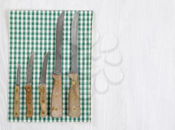 Vintage full knife set with striped cloth napkin on white wood. Format in horizontal layout. 