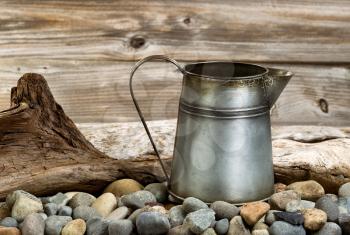 Traditional metal coffee pot on fire pit made of stones and drift wood. 