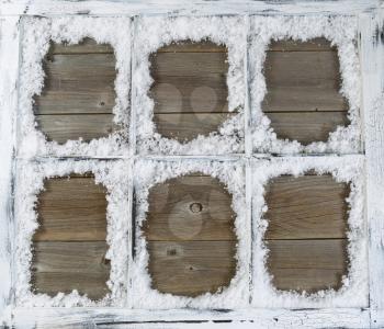 
Vintage six pane window, with powdered snow, on rustic wood.
