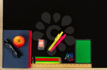 School supplies on blackboard. Back to school concept. 