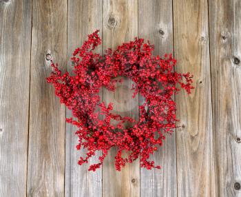 Red holly berry wreath on rustic wood. Boards in vertical layout. 