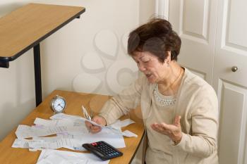 Senior woman upset at her bills. In debt concept. 