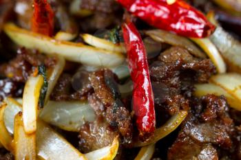 Chinese hot red Chile peppers with beef and vegetables. Filled frame format with selective focus on front pepper. 