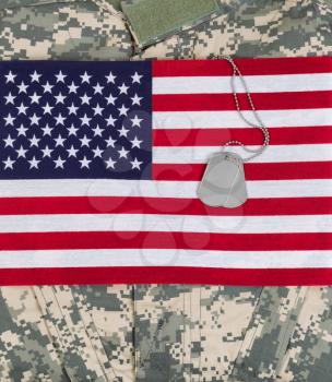 United States of America flag, military identification tags, neck chain, and combat uniform top. Vertical layout. 