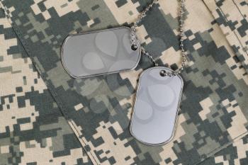 Military identification tags, neck chain, and combat uniform top. Military service concept. 